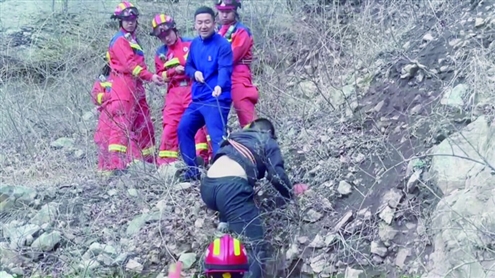 消防救援人员将绳索板带沿崖边抛给被困男子济南消防供图